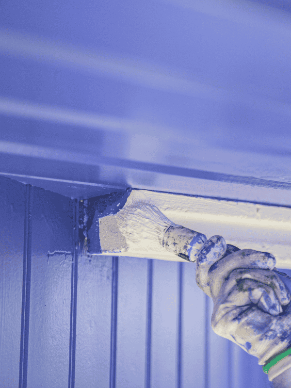Un peintre de l'entreprise godinho peint un mur en bois près de Navarrenx